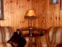 Ретро-лампа с бахромой на столике углового дивана.