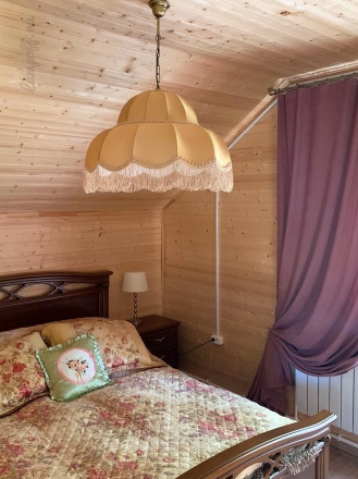 Ретро-абажур кофейного цвета в спальне деревянного дома